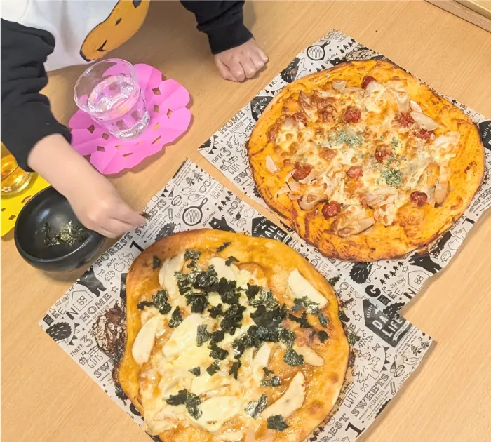 3歳もペストリーボードがあればらくらくピザ成型。生地にトッピングする本日のシェフ