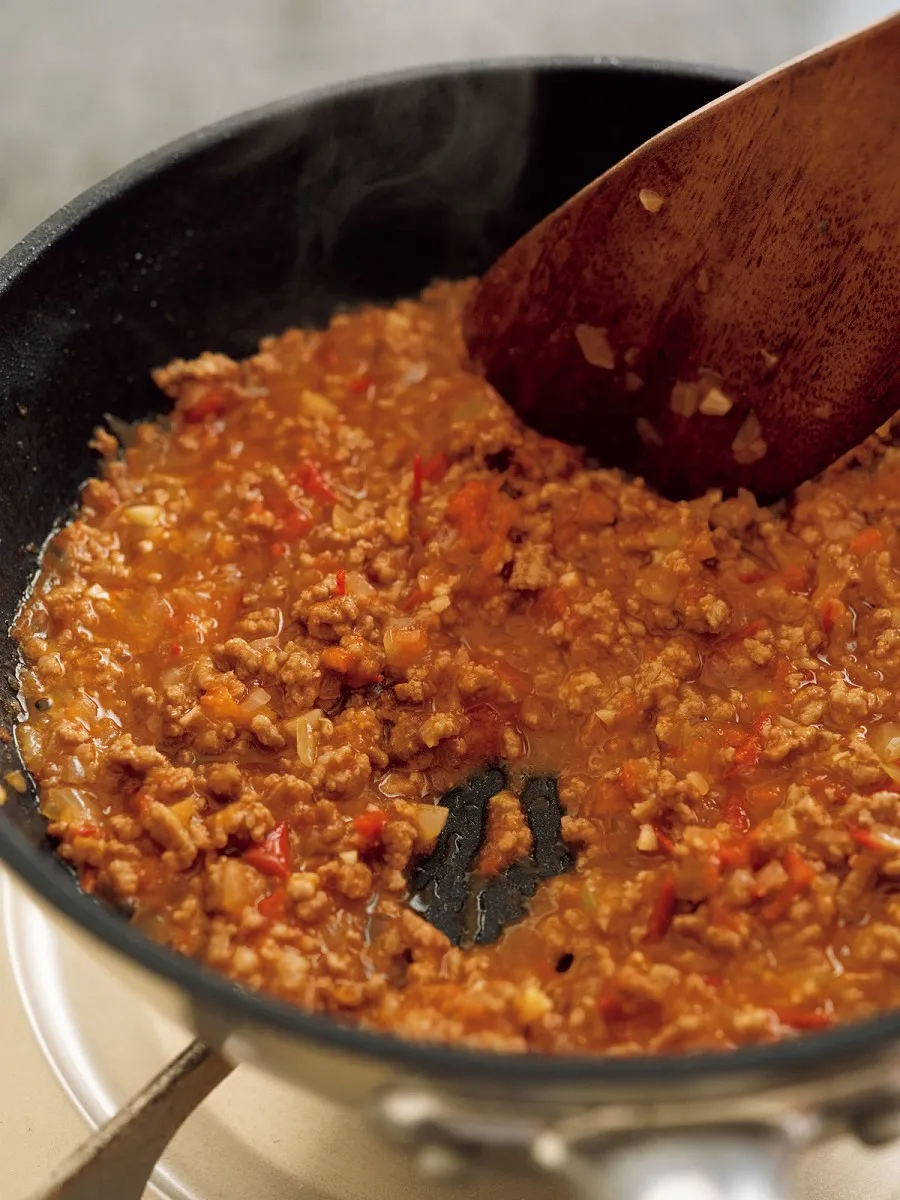 玉ねぎ、ひき肉を炒め、トマトを加える