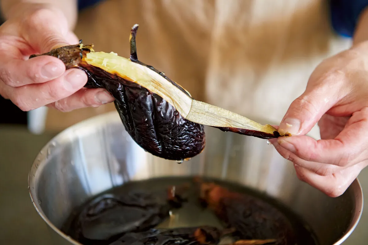 焼いたなすを冷水にとり、皮をむく