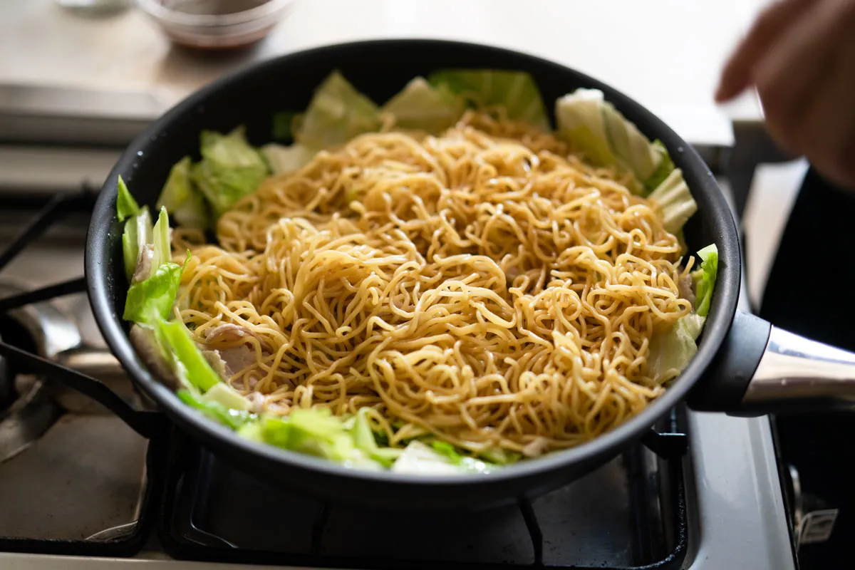 フライパンに焼きそばの麺を加える
